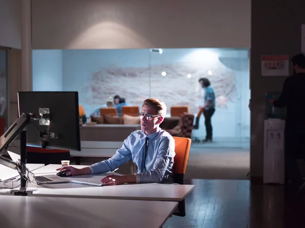 Man aan het werk op computer in donkere kantoor — Stockfoto