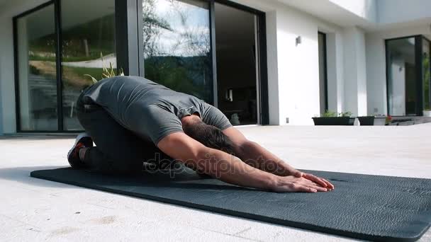 Man doet ochtend yoga oefeningen — Stockvideo