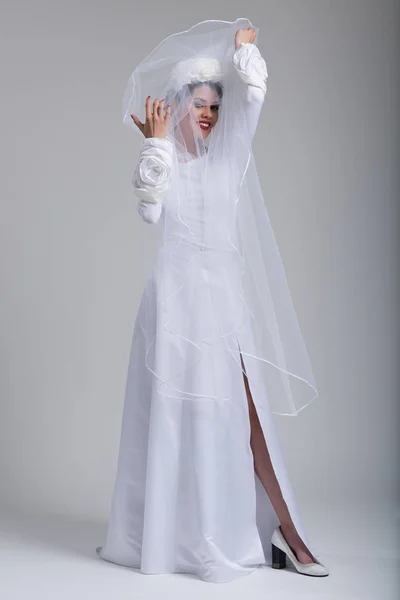 Noiva jovem em um vestido de noiva com um véu — Fotografia de Stock