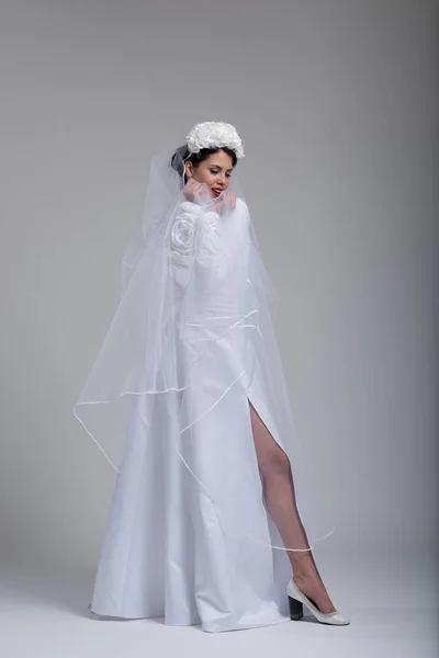 Jeune mariée dans une robe de mariée avec un voile — Photo