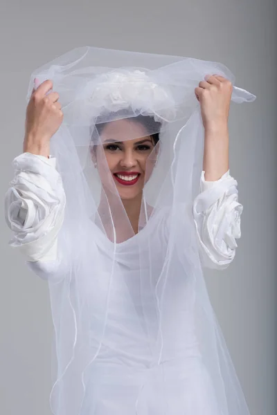 Jeune mariée dans une robe de mariée avec un voile — Photo