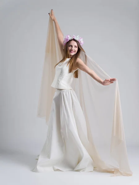 Jeune mariée dans une robe de mariée avec un voile — Photo