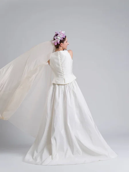 Visão traseira de uma bela jovem mulher em um vestido de noiva — Fotografia de Stock