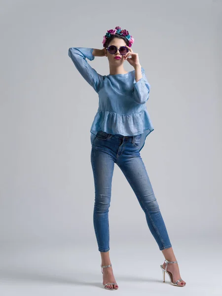 Kvinna poserar i moderiktiga kläder och solglasögon — Stockfoto