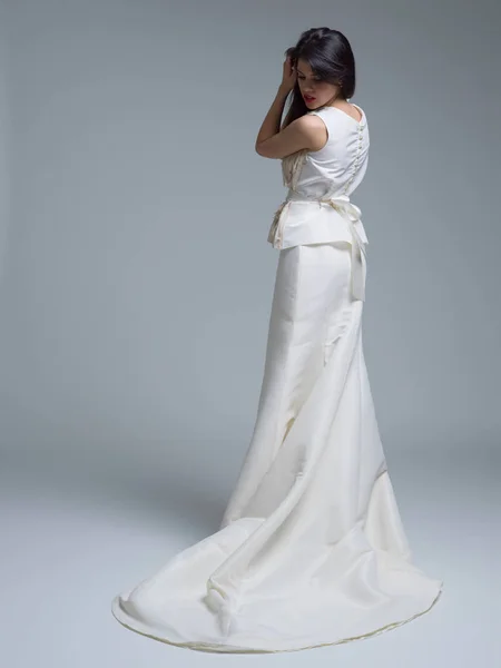 Visão traseira de uma bela jovem mulher em um vestido de noiva — Fotografia de Stock