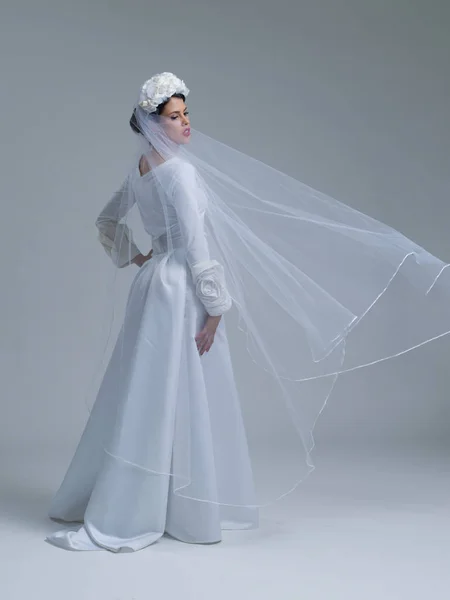 Jonge bruid in een trouwjurk met een sluier — Stockfoto