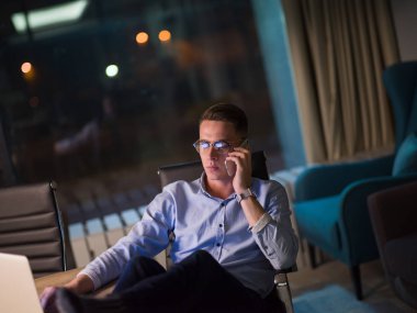 cep telefonuyla karanlık ofisinde işadamı