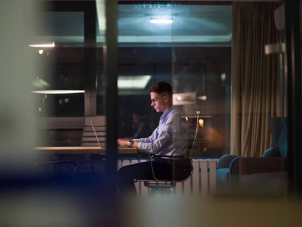 Ο άνθρωπος που εργάζεται για το φορητό υπολογιστή σε σκοτεινή γραφείου — Φωτογραφία Αρχείου