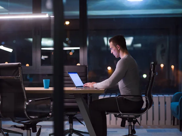 Man som arbetar på laptop i mörka office — Stockfoto