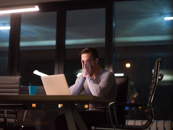Homem trabalhando no laptop no escritório escuro — Fotografia de Stock