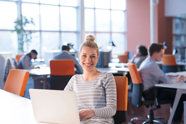 Empresária usando um laptop no escritório de inicialização — Fotografia de Stock