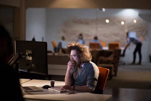 Uomo che lavora al computer in ufficio buio — Foto Stock