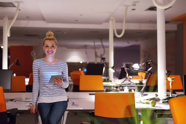 Жінка працює на цифровому планшеті в нічному офісі — стокове фото