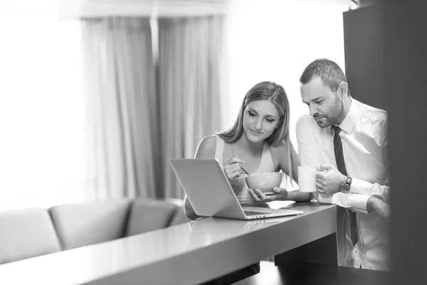 Um jovem casal está se preparando para um emprego e usando um laptop — Fotografia de Stock