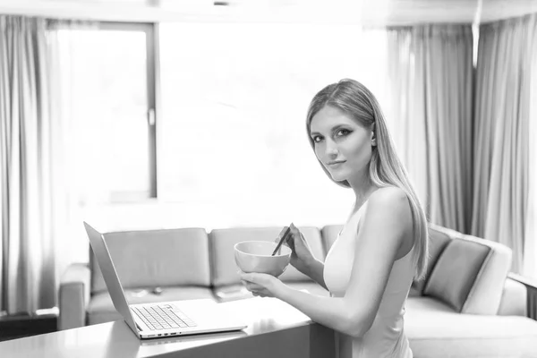 Woman eating breakfast in front of her luxury home — Stock Photo, Image