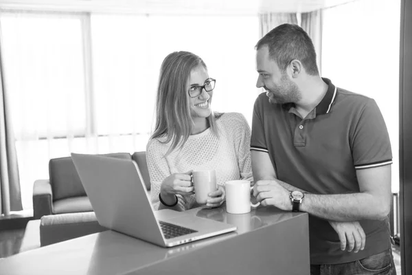 Casal beber café e usando laptop em casa — Fotografia de Stock