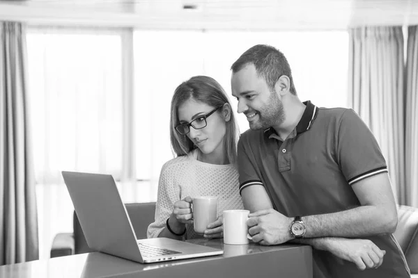 Pareja beber café y el uso de la computadora portátil en casa —  Fotos de Stock