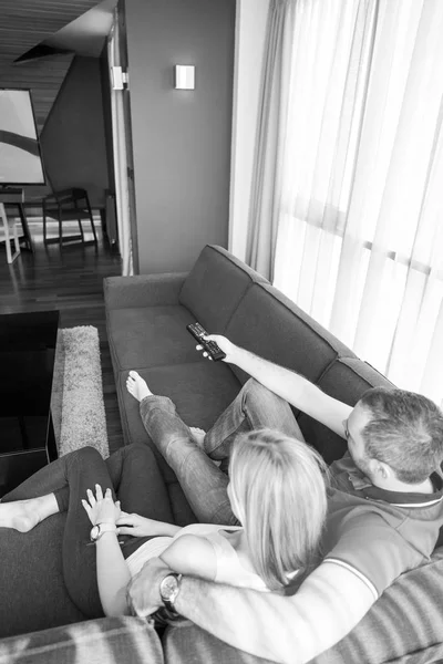 Jovem casal no sofá assistindo televisão — Fotografia de Stock