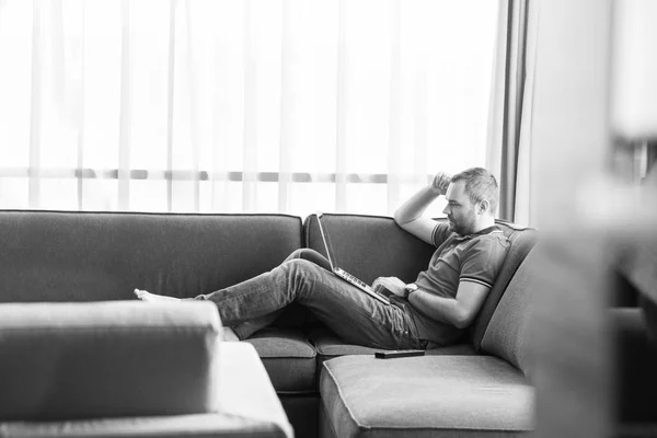 Hombre usando el portátil en la sala de estar — Foto de Stock