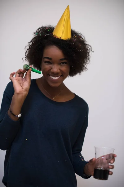 Black woman in party hat blowing in whistle — Stock Photo, Image