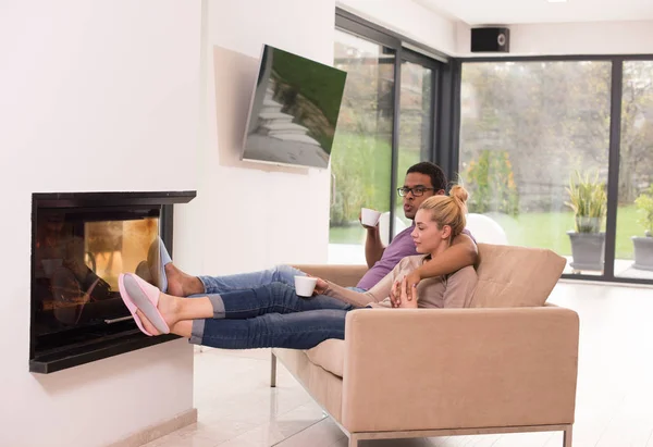 Pareja joven multiétnica frente a la chimenea —  Fotos de Stock