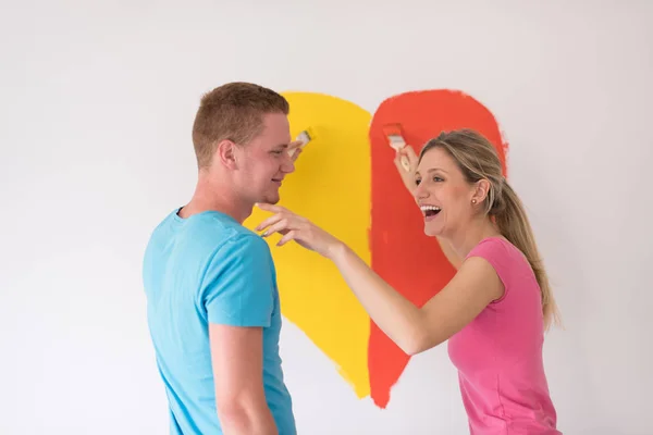 Casal estão pintando um coração na parede — Fotografia de Stock