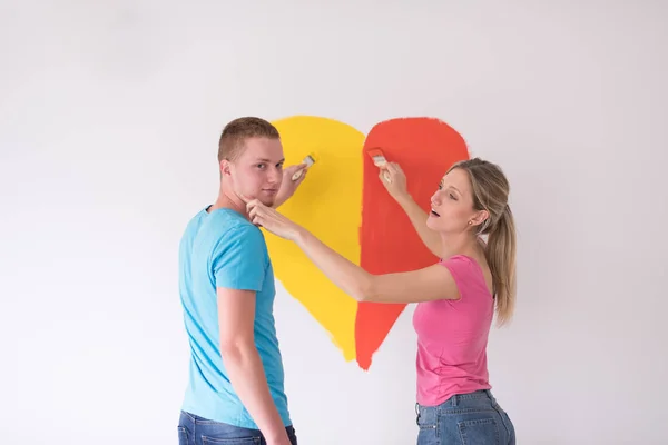 Casal estão pintando um coração na parede — Fotografia de Stock