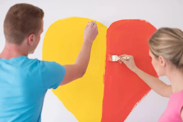 Paar malt ein Herz an die Wand — Stockfoto