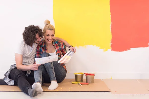 Feliz joven pareja relajándose después de pintar — Foto de Stock