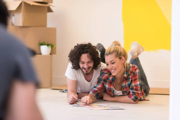 Feliz jovem casal relaxante após a pintura — Fotografia de Stock