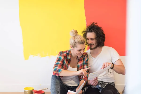 Feliz joven pareja relajándose después de pintar — Foto de Stock