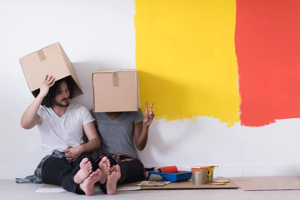 Mnohonárodnostní mladý pár si hraje s lepenkové krabice — Stock fotografie
