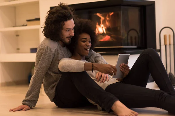 Pareja multiétnica utilizando tableta en el suelo —  Fotos de Stock