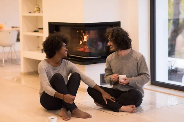 Multiethnisches Paar vor dem Kamin — Stockfoto