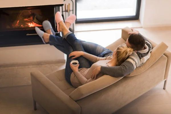 Pareja joven frente a la chimenea —  Fotos de Stock