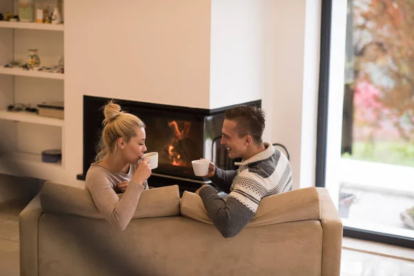 Junges Paar vor Kamin — Stockfoto