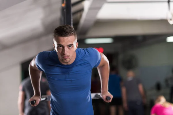 Homem fazendo exercícios barras paralelas — Fotografia de Stock