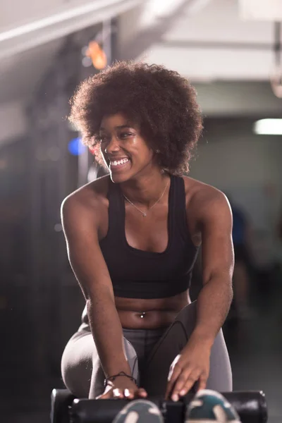 Negro mujer haciendo sit ups en el gimnasio —  Fotos de Stock