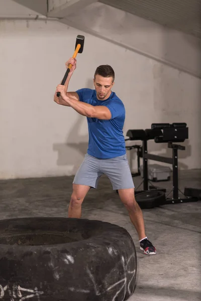 Entrenamiento del hombre con el martillo y el neumático tractor —  Fotos de Stock