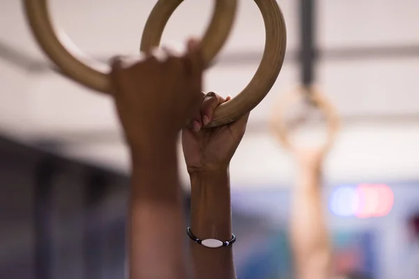 Mains masculines sur les anneaux de gymnastique — Photo