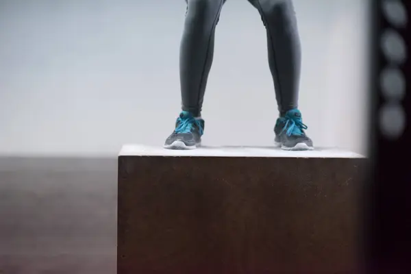 Fekete nő végez box jumps az edzőteremben — Stock Fotó