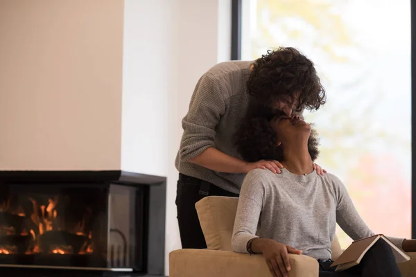 Pareja multiétnica abrazándose frente a la chimenea —  Fotos de Stock