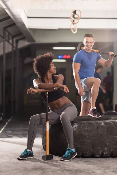 Multiethnic couple after workout with hammer — Stock Photo, Image