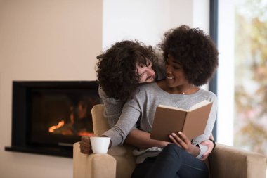 çok ırklı çift şöminenin önünde sarılma