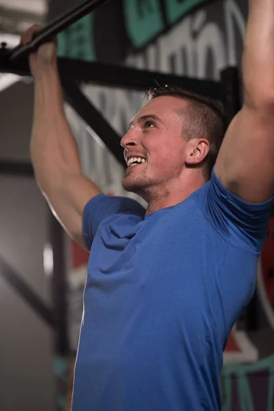 Homem fazendo pull ups — Fotografia de Stock