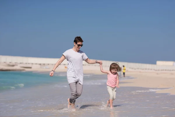 Mutter und Tochter rennen am Strand — Stockfoto