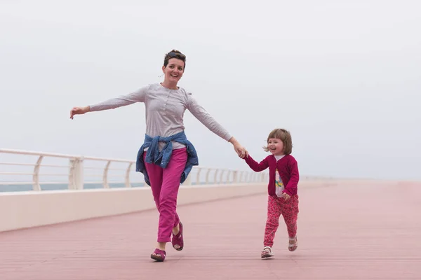 Mãe e linda menina no passeio à beira-mar — Fotografia de Stock