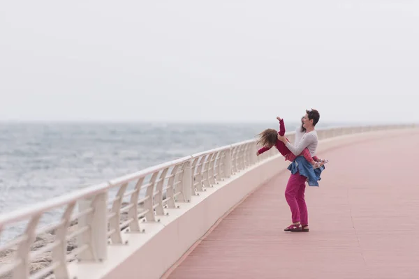 Moeder en schattig klein meisje op de promenade aan de zee — Stockfoto