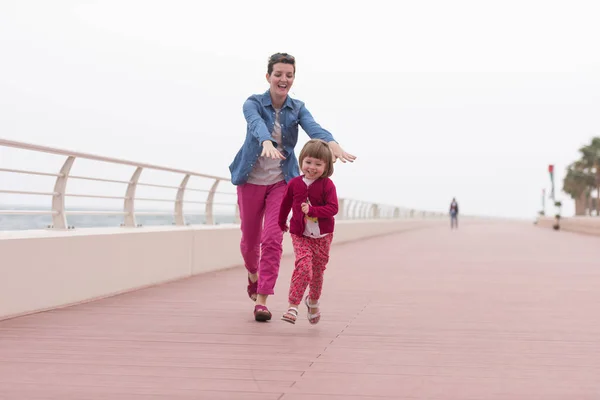 Mutter und süßes kleines Mädchen auf der Promenade am Meer — Stockfoto