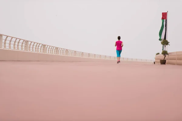 Kvinna upptagen kör på strandpromenaden — Stockfoto